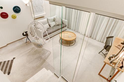a glass room with a chair and a table at Anemolia Parga Suites in Sarakiniko