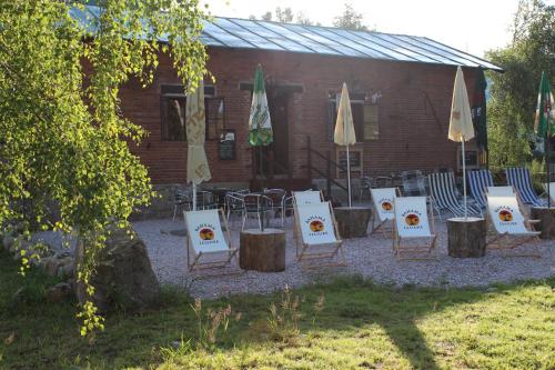 a group of chairs and umbrellas in front of a building at Penzion Varšavjanka in Harrachov
