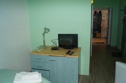 a room with a bed and a desk with a television at Penzion Blatno in Blatno