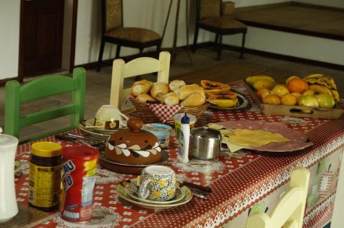 a table with a table cloth with food on it at Vila Palmar Hospedagem in Vassouras