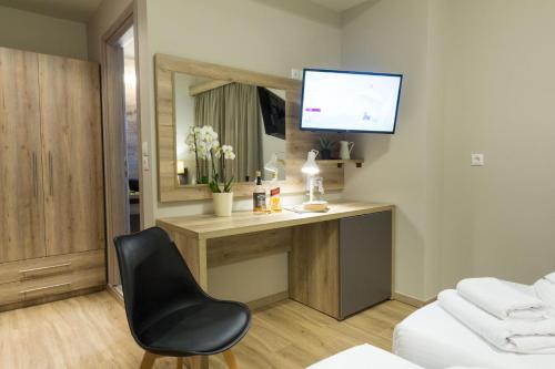 a room with a desk with a chair and a television at Hotel @Syngrou Fix in Athens