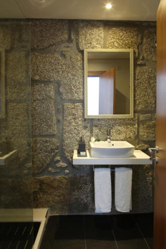 a bathroom with a sink and a mirror at Solar Egas Moniz-Charming House & Local Experiences in Paço de Sousa