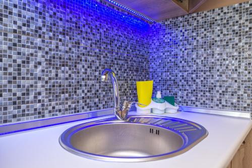 a bathroom sink with a faucet and purple lights at Marinas Apartments Alexandroupolis in Alexandroupoli