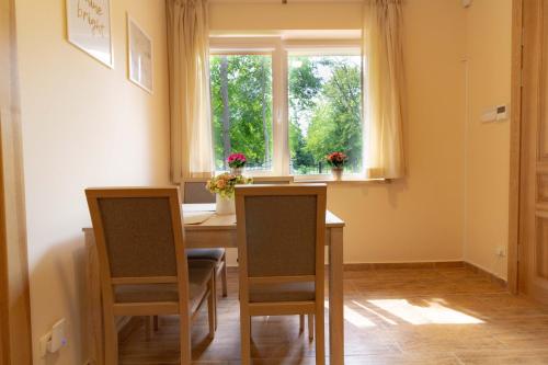 una sala da pranzo con un tavolo e due sedie e una finestra di Vila Estate a Palanga