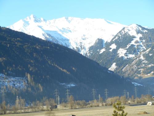 a snow covered mountain with a train in a field at Hotel Gasthof Schweizerhaus in Stuhlfelden