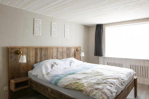 a bed with a wooden headboard in a bedroom at Villa Maxime in Ostend