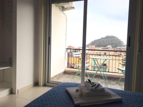 a bedroom with a bed and a window with a view at Blue Sky Apartments in Capo dʼOrlando