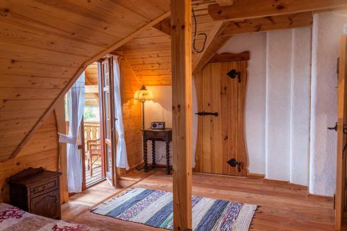 a bedroom in a log cabin with a large window at Dar Kalu -Sosnowy Gaj in Węgorzewo