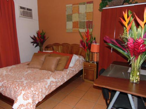 a bedroom with a bed and a table with flowers at Casa Lima B&B in San José