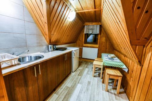 eine Küche mit Holzschränken, einer Spüle und einem Tisch in der Unterkunft Pokoje Gościnne Makuszyńskiego in Zakopane