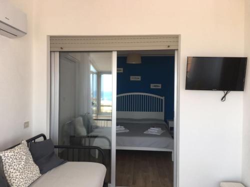 a living room with a bed and a sliding glass door at Blue Sky Apartments in Capo dʼOrlando