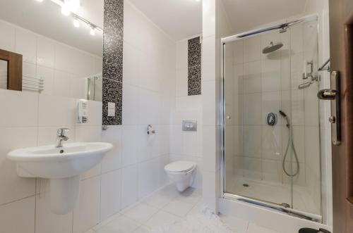 a white bathroom with a sink and a shower at Willa Mycyny oraz domki in Mycyny