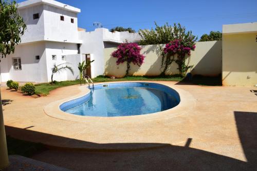 a swimming pool in the yard of a house at Villa Du Soleil Ngaparou in Ngaparou