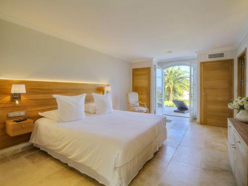 1 dormitorio con 1 cama blanca grande y balcón en Villa Orchard, en Saint-Tropez