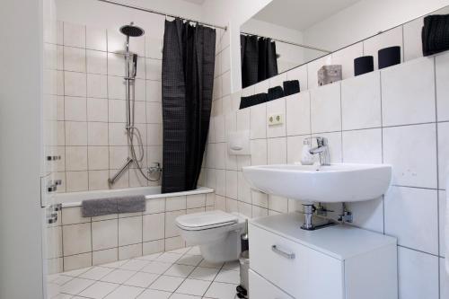 La salle de bains est pourvue d'un lavabo, de toilettes et d'une douche. dans l'établissement Ferienwohnung am Völkerschlachtdenkmal, à Leipzig