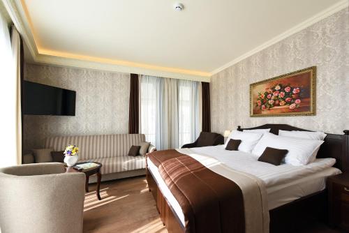 a hotel room with a large bed and a couch at KEY for REST in Palanga
