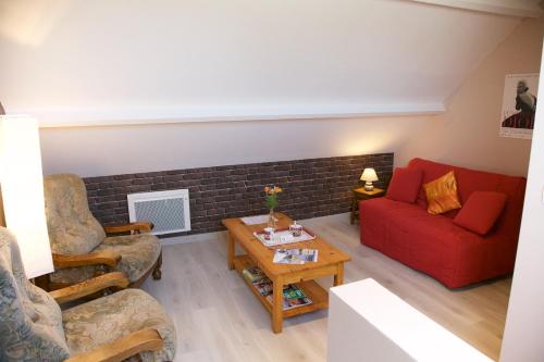 - un salon avec un canapé et des fauteuils rouges dans l'établissement La Petite Chesnee, à Sacey