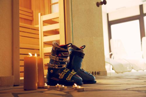 a pair of boots sitting next to a candle at Pippo Hotel in Terzolas