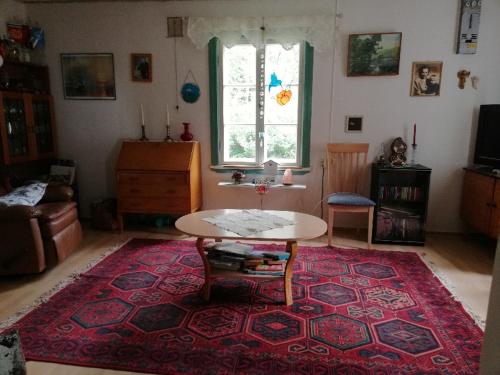 a living room with a table and a rug at Mökki Kujala in Nummi