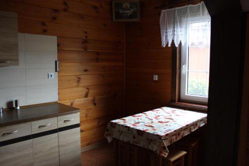 a kitchen with a bench in a room with a window at U Romaniuków in Werstok