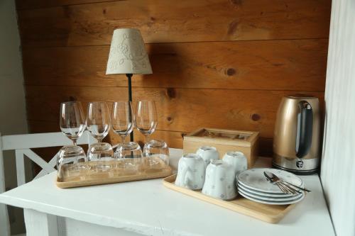 a table with wine glasses and a lamp on it at Pension Angusfarm in Soběsuky