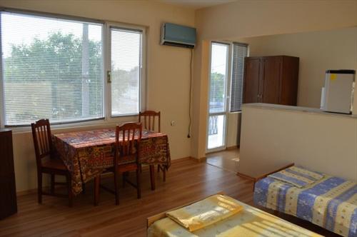 a living room with a table and chairs and a bed at Къща за гости "Черната роза" in Bŭlgarevo