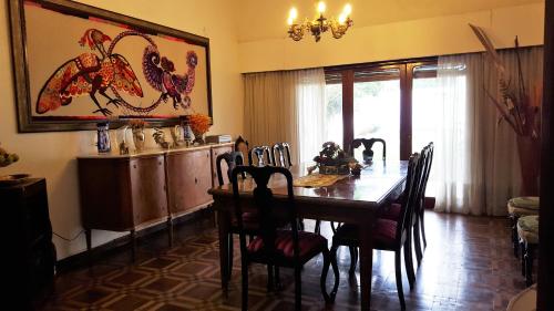 uma sala de jantar com uma mesa de madeira e cadeiras em La Maison em San Fernando del Valle de Catamarca