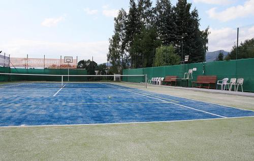 een tennisbaan met stoelen erop bij Penzion Real in Žiar
