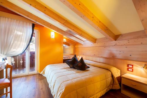 a bedroom with a bed in a room with wooden walls at Hotel La Serenella in Moena