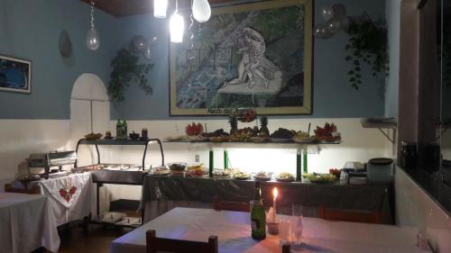 a dining room with a table and a kitchen at Hotel Planalto in Poços de Caldas