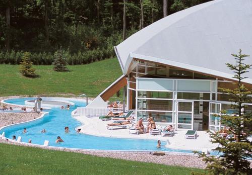 une grande piscine avec des gens dans un complexe hôtelier dans l'établissement Gîte 100m2, jardin privé, 3 chambres à Mondelange, à Mondelange