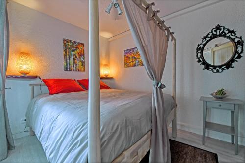 a bedroom with a canopy bed and a mirror at T2 cosy de 41m2 à 400 m de la plage, résidence avec piscine. in Le Grau-du-Roi