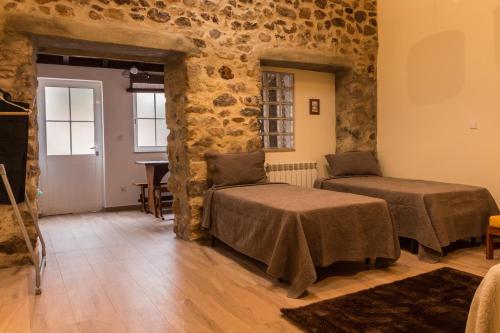 a room with two beds and a table at Portantiqua, guest house in Góis