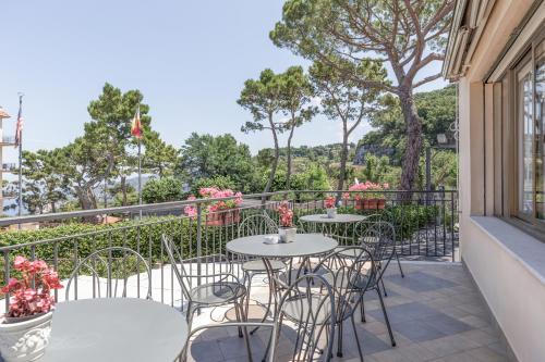 a patio with tables and chairs on a balcony at Hotel La Pergoletta in SantʼAgata sui Due Golfi