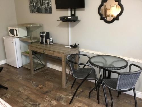 a kitchen with a table and chairs and a microwave at Motel La Source in Coaticook