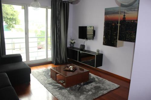 - un salon avec un canapé et une télévision dans l'établissement Uptown Madalenas, à Funchal