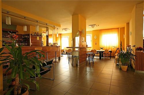 a large room with tables and chairs and plants at Hotel Giada in Turin