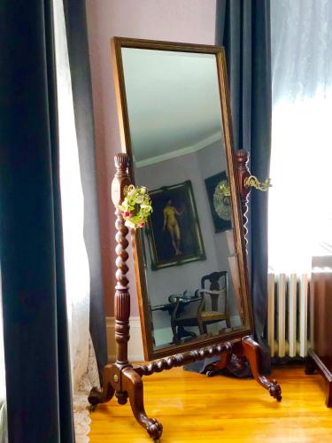 a mirror on a wooden stand in front of a room at 1000 Islands Bed and Breakfast-The Bulloch House in Gananoque