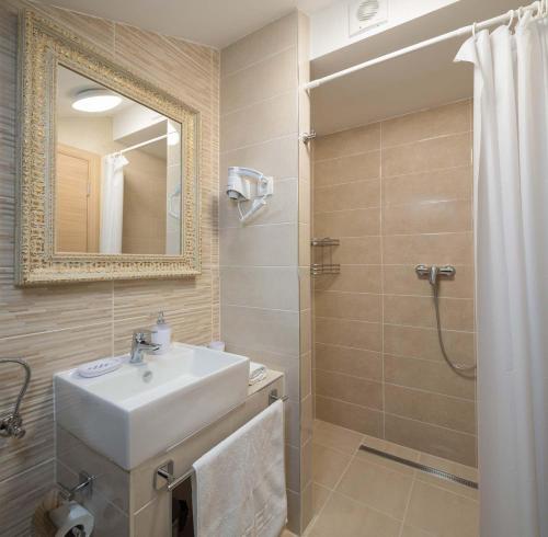 uma casa de banho com um lavatório e um chuveiro com um espelho. em Villa Charlotte em Omiš