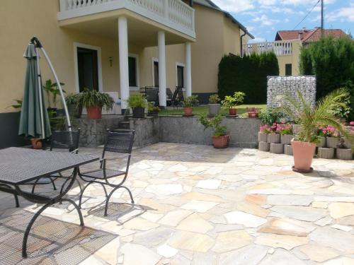 eine Terrasse mit einem Tisch, Stühlen und einem Sonnenschirm in der Unterkunft Garten- & Loggia-Appartement HERRENHAUS in Dellach im Drautal