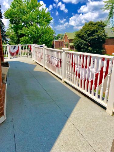 a white fence with red and white decorations on it at 1000 Islands Bed and Breakfast-The Bulloch House in Gananoque