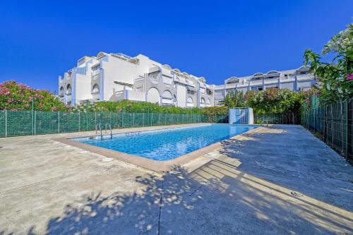 une piscine devant un immeuble dans l'établissement T2 cosy de 41m2 à 400 m de la plage, résidence avec piscine., au Grau-du-Roi