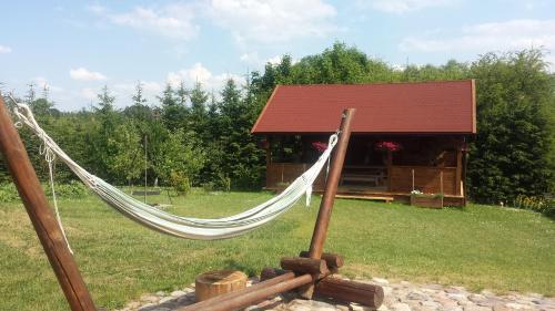 a hammock in front of a log cabin at Gospodarstwo Agroturystyczne Rowerowa Przystań "Jankesówka" in Lidzbark Warmiński