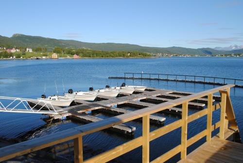 two boats are docked at a dock on a lake at Furoy Hotel Apartments and Boating in Sorreisa