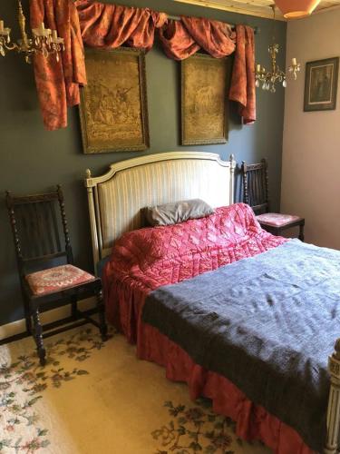 a bedroom with a bed and two chairs at Gernos Farmhouse in Llandysul
