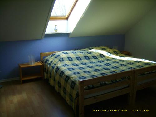 a bedroom with a bed with a window above it at Haus Marinus in Puttgarden
