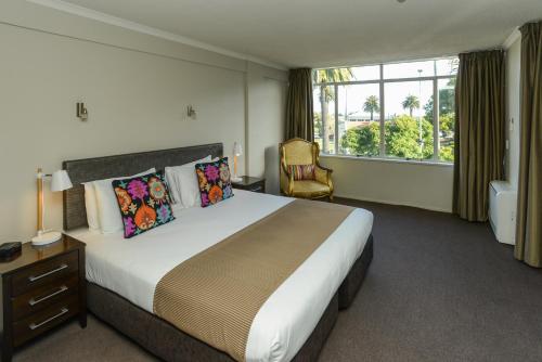 um quarto de hotel com uma cama grande e uma janela em expressotel em Napier