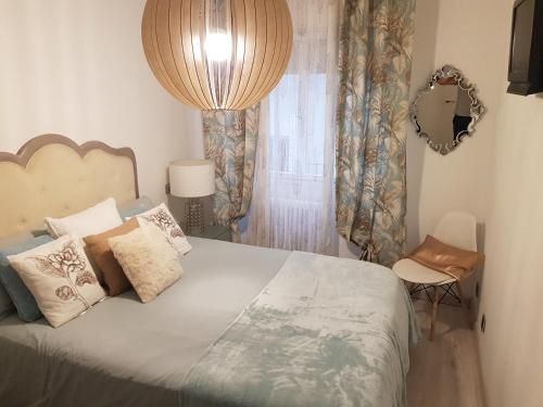 una camera con un grande letto e uno specchio di Apartamento la Escalerona con vistas al mar a Gijón