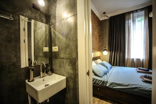 a bathroom with a sink and a bed at Classy Apartments Central in Tbilisi City