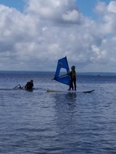 two people on surfboards with a kite in the water at Kwatery u Rybaka in Kuźnica